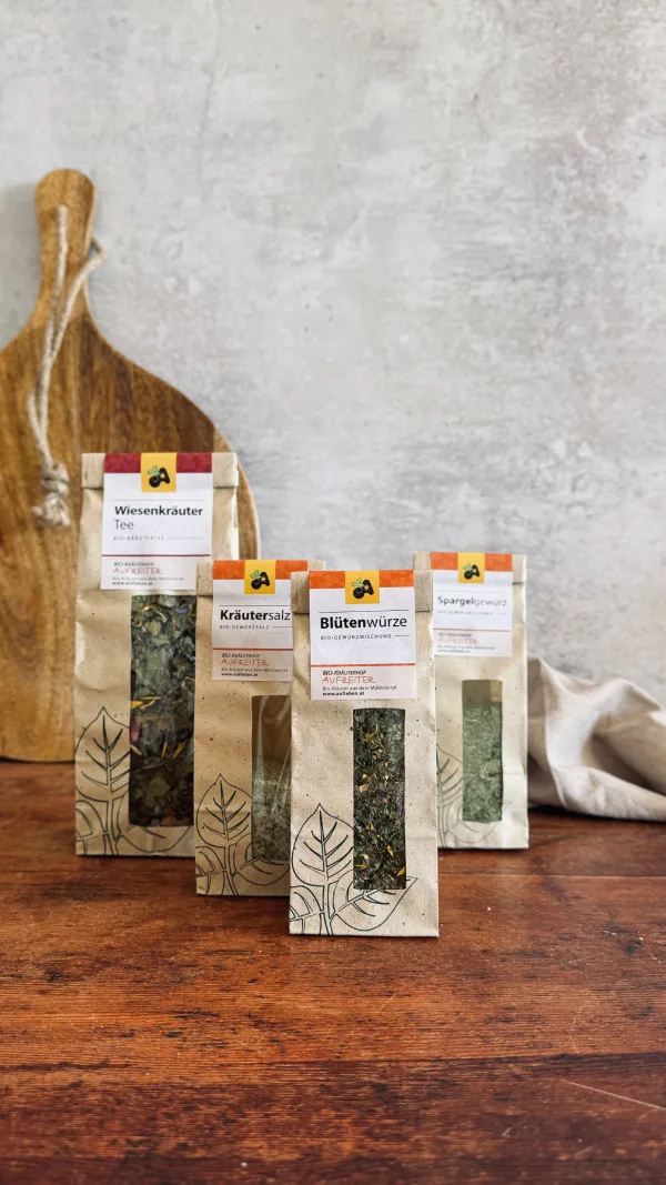 Verschiedene Kräuterprodukte auf Holztisch ausgestellt.